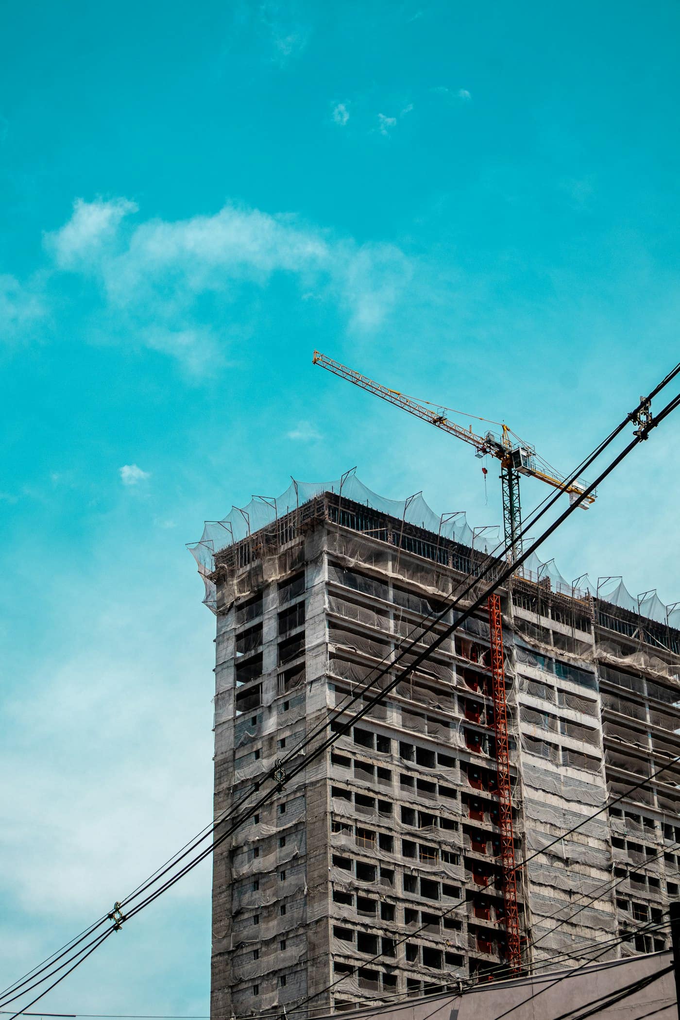 Tower crane beside a high-rise frame under construction